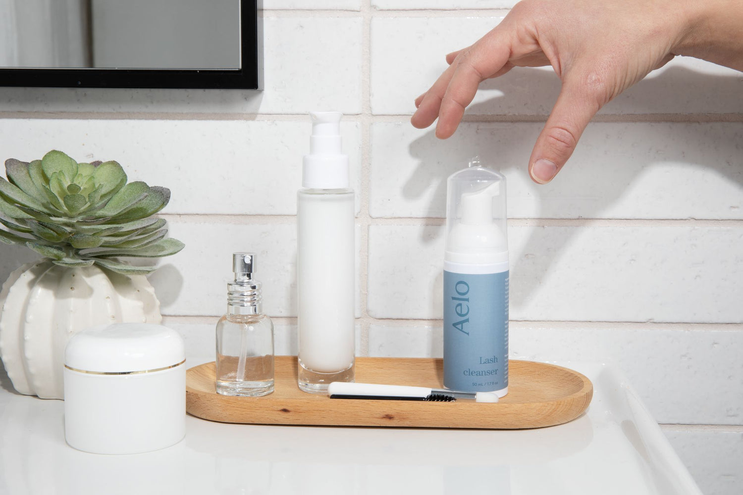 Aelo Eyelid and Eyelash Cleanser in Bathroom Background with Model Hand