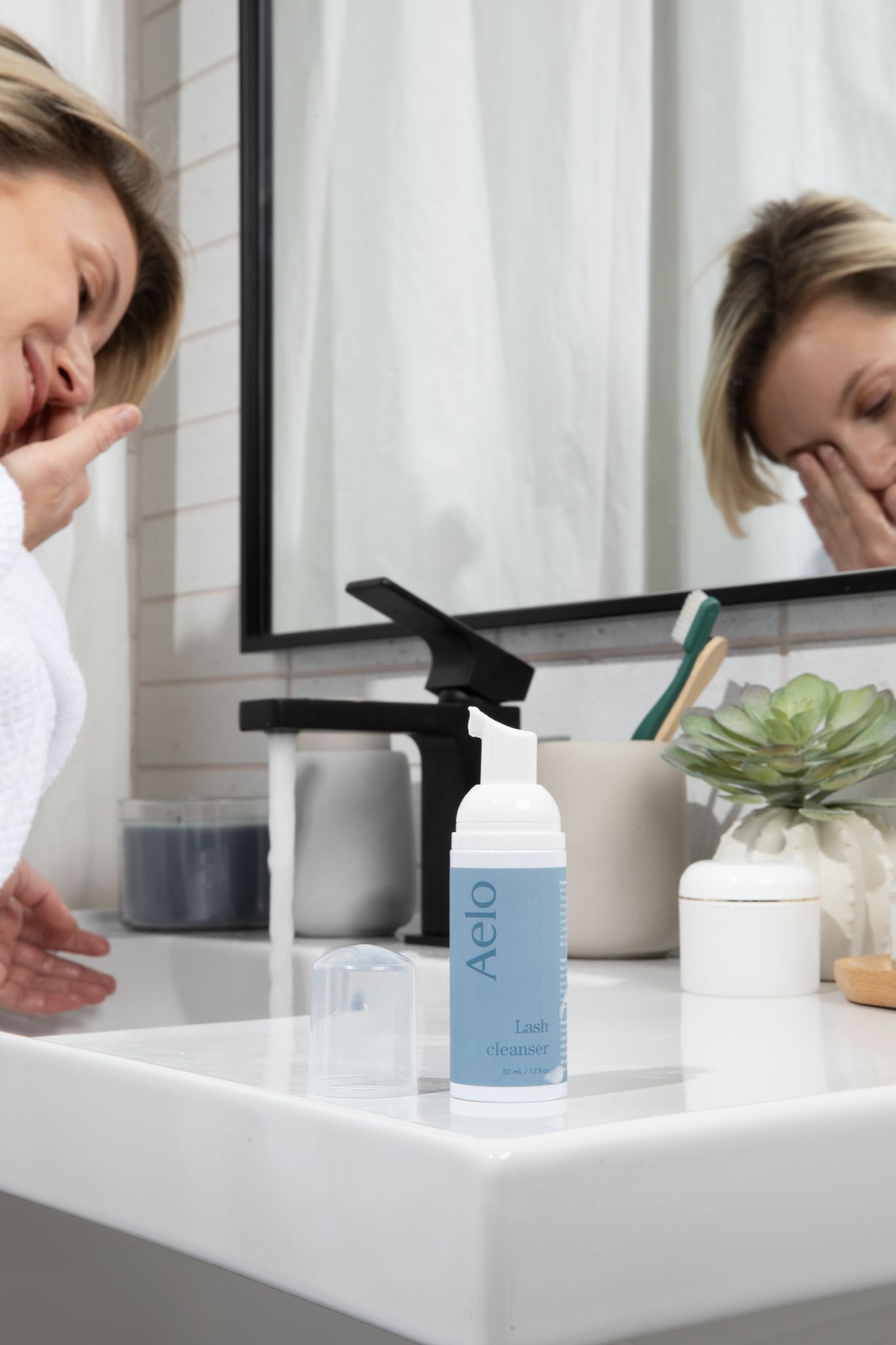 Aelo Eyelid and Eyelash Cleanser in Bathroom Background with Model Washing Eyes 